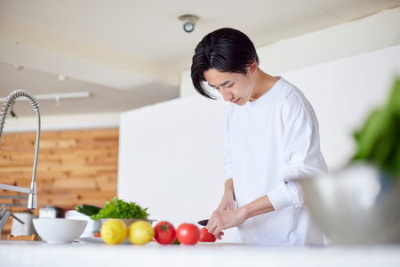 Young Japan man cooking in kitchenの写真素材