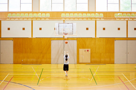 Japan woman in sportswear practicing basketball in gymnasiumの写真素材