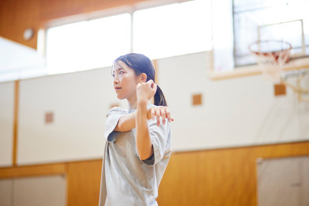 Japan woman wearing sportswear stretching in gymnasiumの写真素材