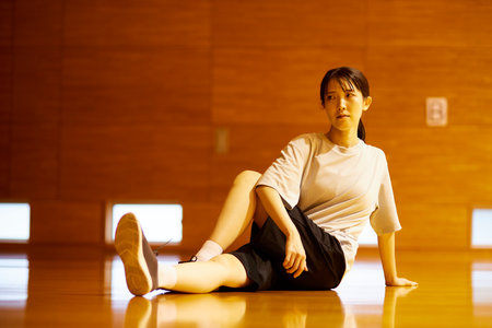 Japan woman wearing sportswear stretching in gymnasiumの写真素材