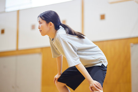 Japan woman wearing sportswear stretching in gymnasiumの写真素材