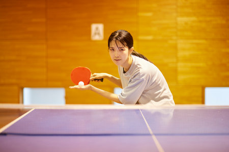 Japan woman wearing sportswear practicing table tennis in gymnasium