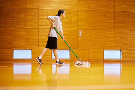 Japan woman wearing sportswear mopping in gymnasiumの写真素材