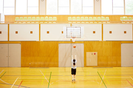 Japan woman in sportswear practicing basketball in gymnasiumの写真素材