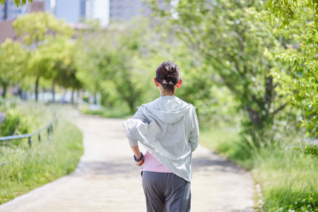 Senior woman wearing sportswear enjoying running in fresh spring greeneryの写真素材