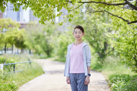 Japan senior woman wearing sportswear in fresh spring greeneryの写真素材