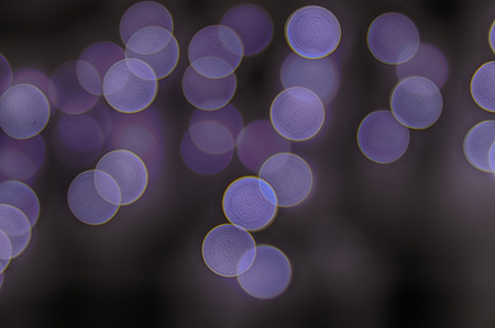 Abstract blurred colorful lights with bokeh effect on dark background.の写真素材