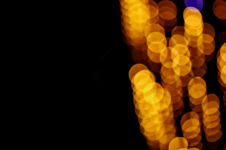 Blurred bright golden lights with a bokeh effect on a dark background.