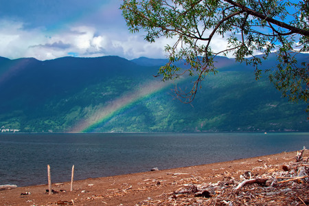 Rainbow over the lake in the background of the mountains.の写真素材