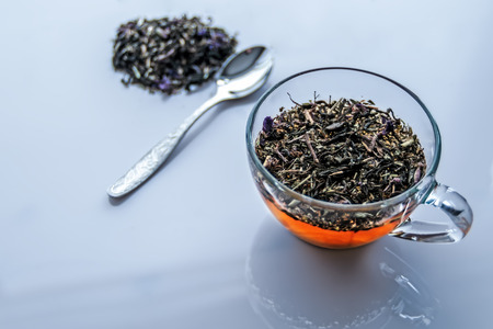 Glass cup with tea, with tea leaves and spoon. View from the top.の写真素材