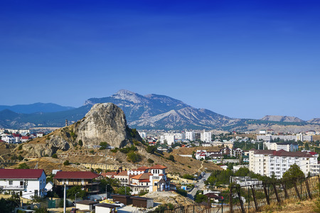 Summer landscape of the city between the mountains in clear sunny weather with a blue sky.の写真素材