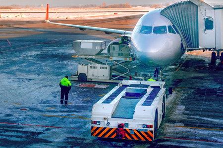 Aircraft being attached to jetway or passenger telescopic gangway on airport apron. Prepares for boarding passengers through telescopic ladder.の写真素材