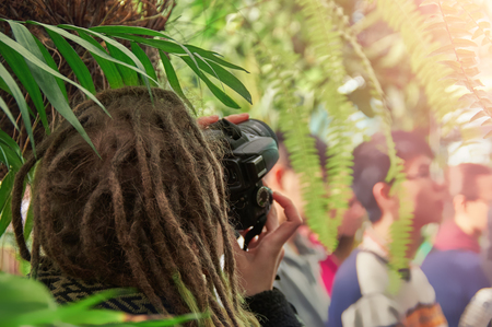 Concept: photography on an excursion. Photographer with dreadlocks on his head shooting in...