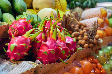 Concept asian food market. Berries dragon fruit (Pitahaya) on counter street night vendor of fruits. Exotic tropical fruits.の写真素材