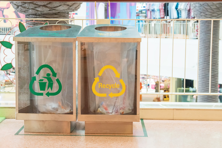 Modern transparent containers with signs for separate garbage and biodegradable waste in the mall. Urban waste separate collection system. Contemporary design.の写真素材
