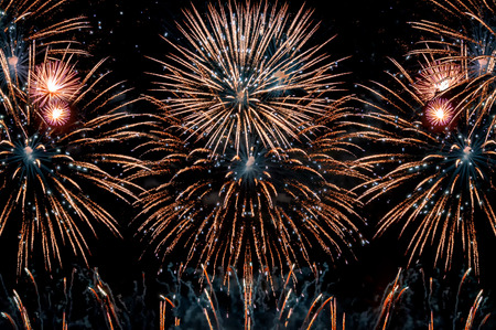Fireworks at New Year abstract holiday background. Colorful big fireworks on black night background.
