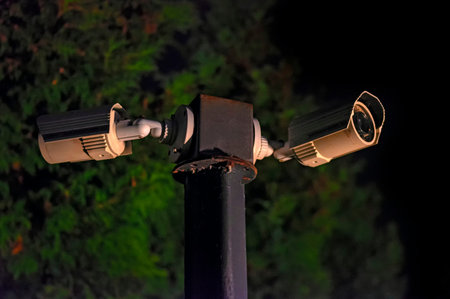 Modern surveillance cameras on the dark night street. Two Cctv security cameras. Night town.