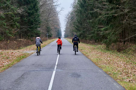 Family cycling in autumn park.の写真素材