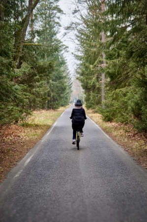Girl on bicycle rides in autumn foggy park.の写真素材