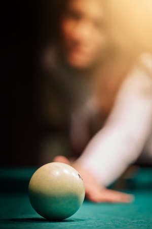 Blurry silhouette of a girl playing billiards.の写真素材