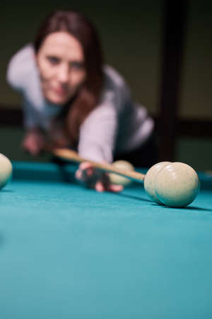 Blurry silhouette of a girl playing billiards.の写真素材