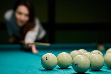 Blurry silhouette of a girl playing billiards.