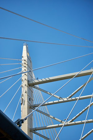 Ropes of a cable-stayed bridge against a blue sky.の写真素材