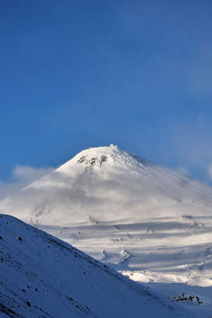 mountain landscape. Volcano peak of mountains over white thick cloudsの写真素材