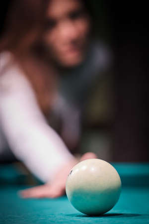 Blurry silhouette of a girl playing billiards.の写真素材