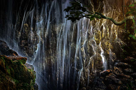A large waterfall in the sun's rays tropical mysterious fairy jungle.の写真素材