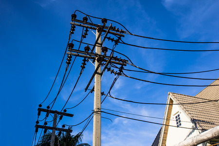 A pole with power lines transporting electricity.の写真素材