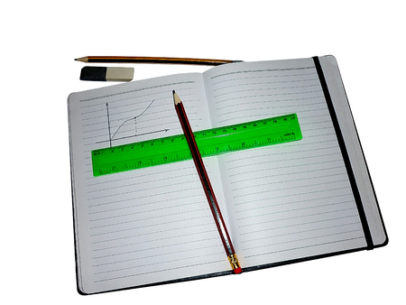 DRAW A SCHEDULE IN THE NOTEBOOK WITH A LINEAR AND A PENCILの写真素材