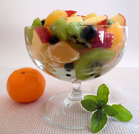fruit salad on a light background orange kiwi apple mandarinの写真素材