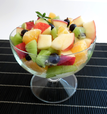 fruit salad on a darkbackground orange kiwi apple mandarinの写真素材
