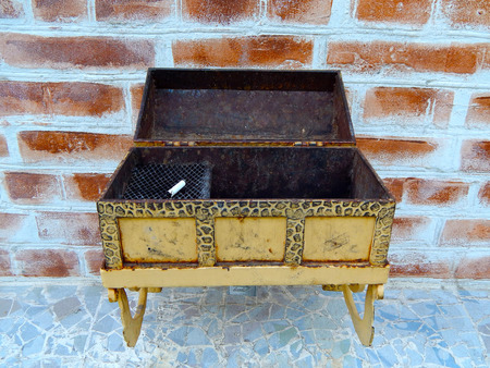 iron decorative ashtray hanging on the wall of a brick house.の写真素材