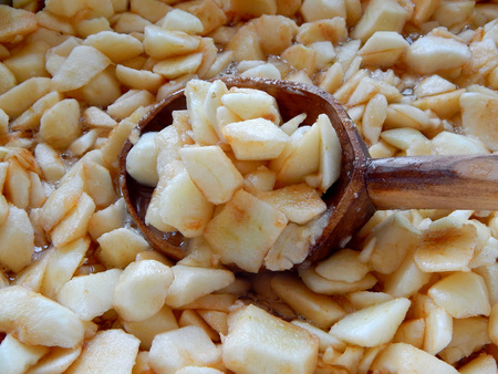 apples sliced in slices with squares in a wooden spoon, apple jam is brewed.の写真素材