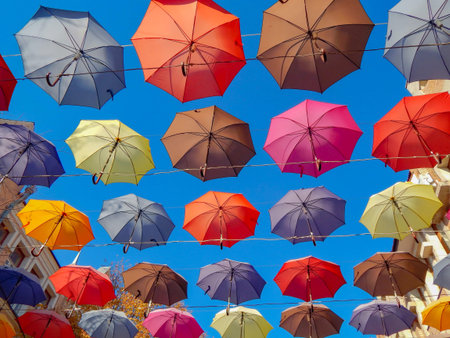 colorful umbrellas soaring hanging in the blue skyの写真素材