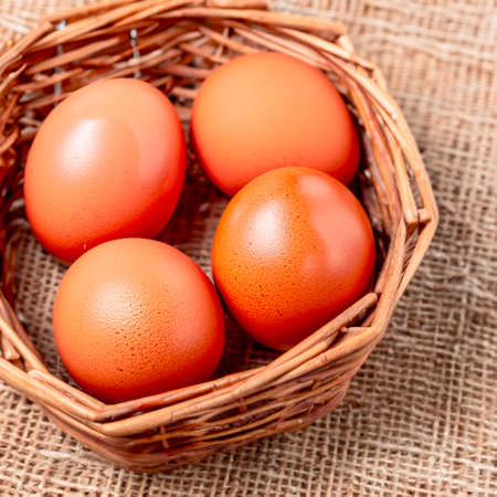 Chicken brown eggs in a wicker wooden basket Generative AIの素材
