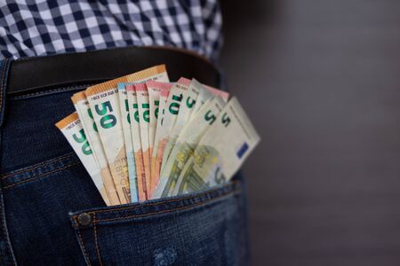 Euro banknotes in jeans back pocket. Concept of rich people, saving or spending money.の写真素材