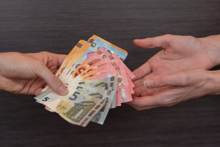 Banker gives young man a loan, isolated background. Concept for receiving payments. Isolated Hands...