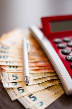 Budget planning concept. Calculator, euro currency banknotes and a table on the home officeの写真素材