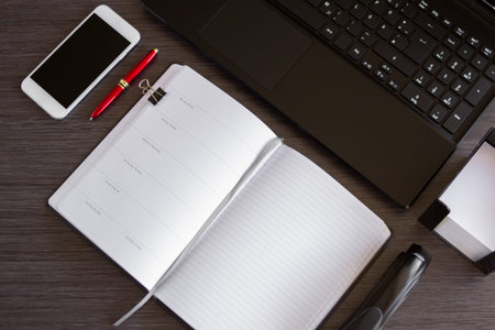 Innovative office desk with smart phone, laptop and a notebook. Concept for business and smart...