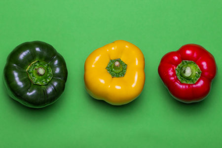 Green, yellow and red peppers on a light green background. Fresh vegetables in natural colors. Food...