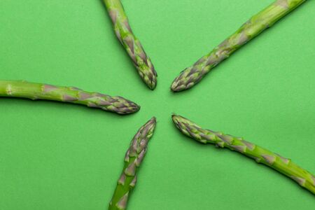 Green raw and healthy asparagus on green background. Detox and superfood concept.の写真素材