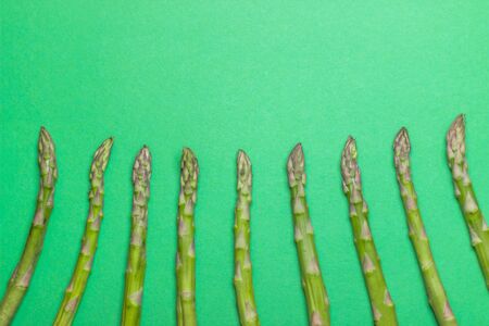 Green raw and healthy asparagus on green background. Detox and superfood concept.の写真素材