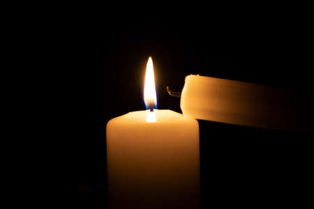 burned small candle next to a big burning oneの写真素材