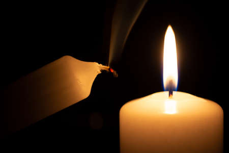 smoking small candle next to a burning big oneの写真素材