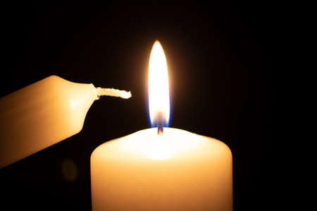 a small candle next to a big one right before ignitionの写真素材