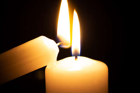 two burning candles next to eachother after ignitingの写真素材