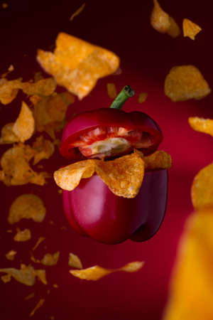Food concept art of a flying pepper with chips. Levitating pepper with tasty junk food.の写真素材
